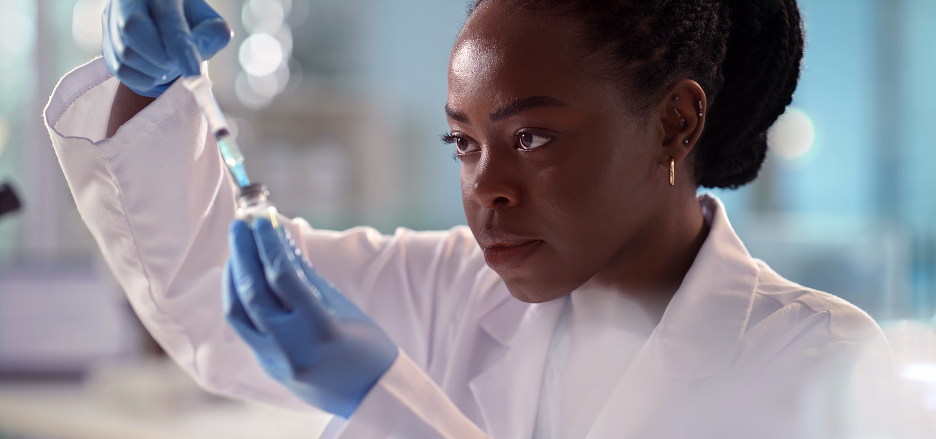Scientist filling glass vial from pipette