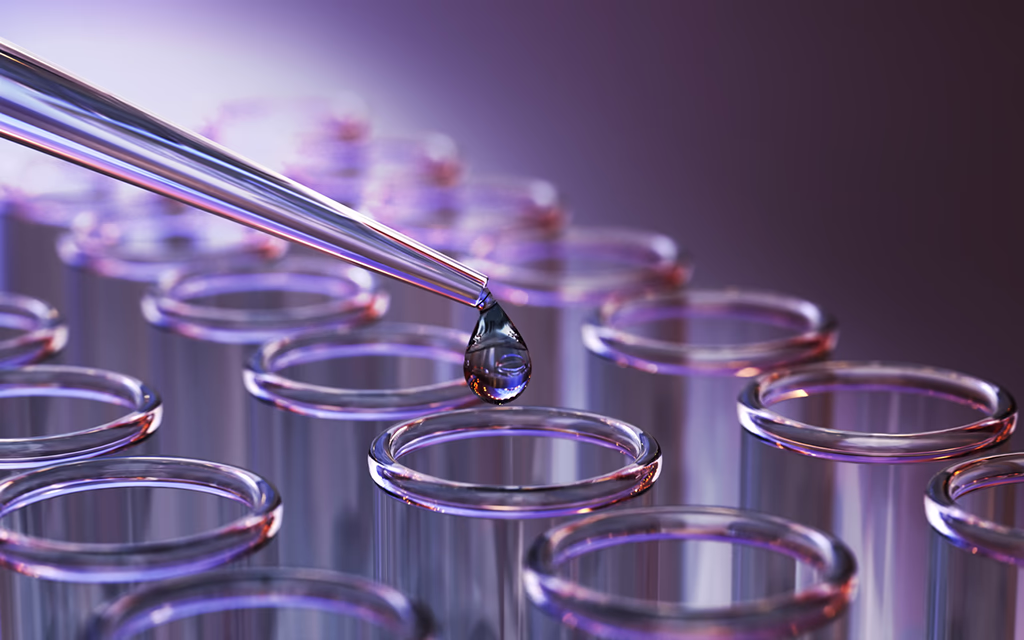 Glass vials with liquid being dispensed via pipette, close up, shallow depth of field